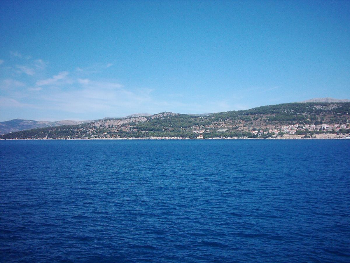 Pogled s trajekta na duboko plavo more i otok na obzoru