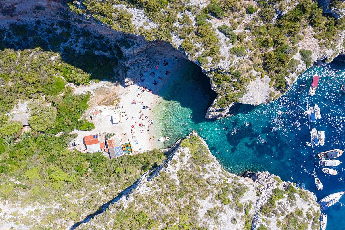 Pogled iz zraka na skrivenu uvalu s malom šljunčanom plažom među liticama